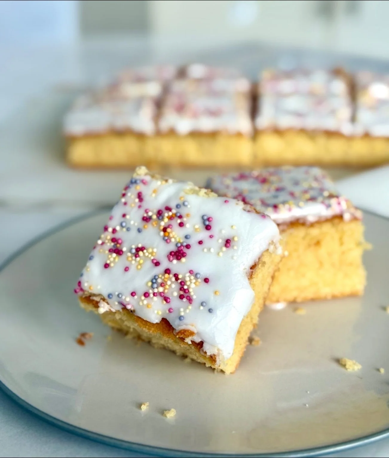 Iced vanilla tray bake with colourful sprinkles